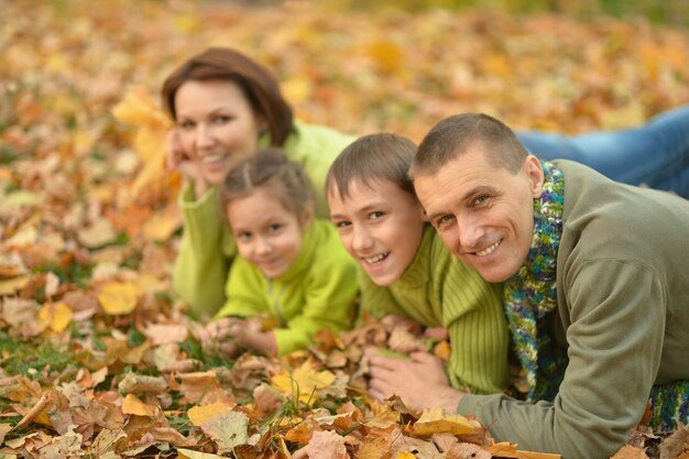 Família feliz e sorridente relaxando no parque de outono