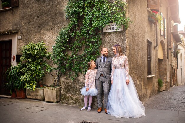 Una familia feliz y elegante se encuentra en el casco antiguo de Sirmione en Italia