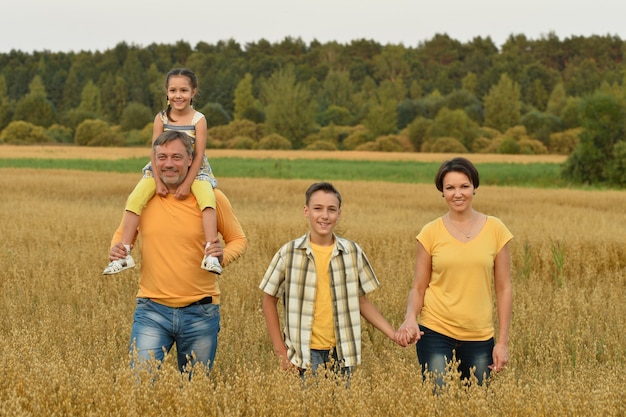 Família feliz em campo de trigo em dia ensolarado