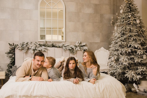 Família feliz em casa na cama Conceito de ano novo