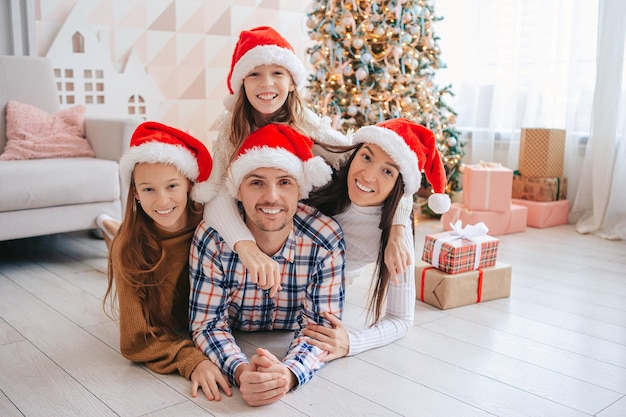 Família feliz em chapéus de Papai Noel nas férias de Natal em casa