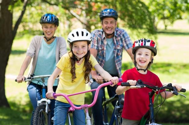 Família feliz em sua bicicleta no parque
