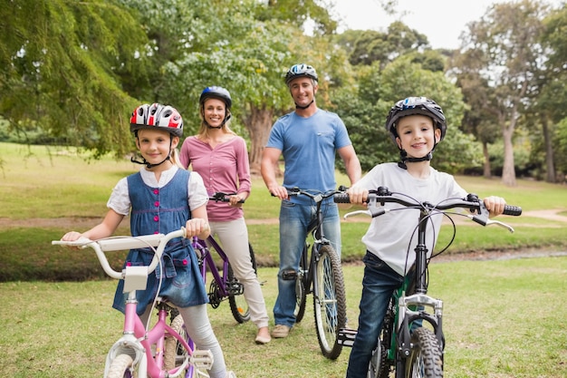 Família feliz em sua bicicleta no parque