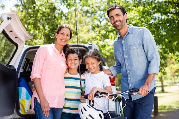 Família feliz em um piquenique ao lado de seu carro