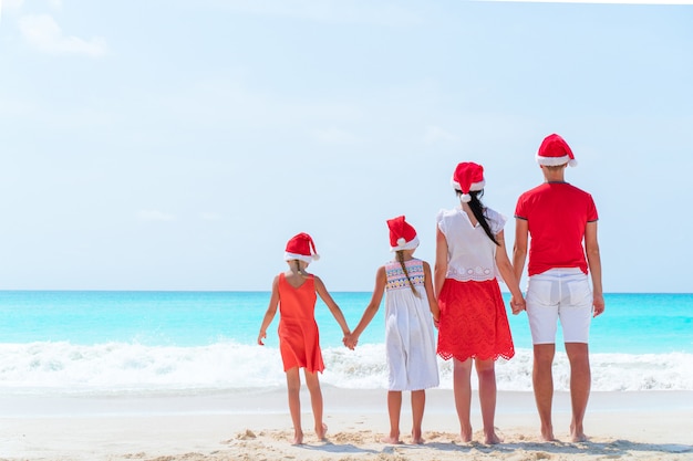 Família feliz, em, vermelho, chapéus santa, ligado, um, praia tropical, celebrando, natal, férias