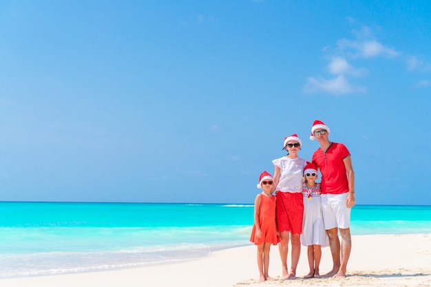 Família feliz, em, vermelho, chapéus santa, ligado, um, praia tropical, celebrando, natal, férias