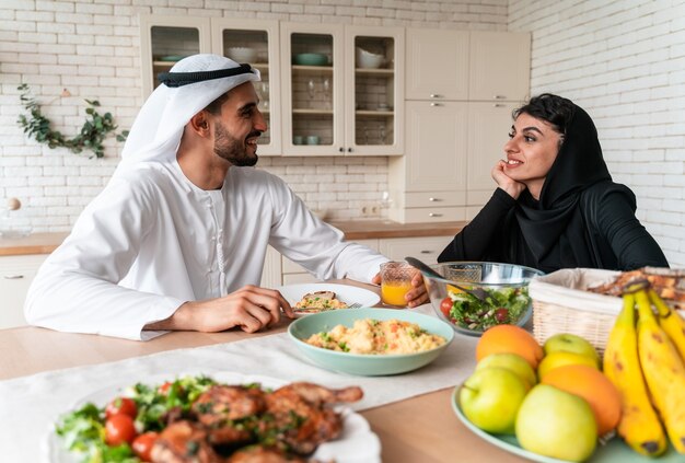 Familia feliz de los emiratos árabes unidos comiendo juntos y celebrando las fiestas del día nacional