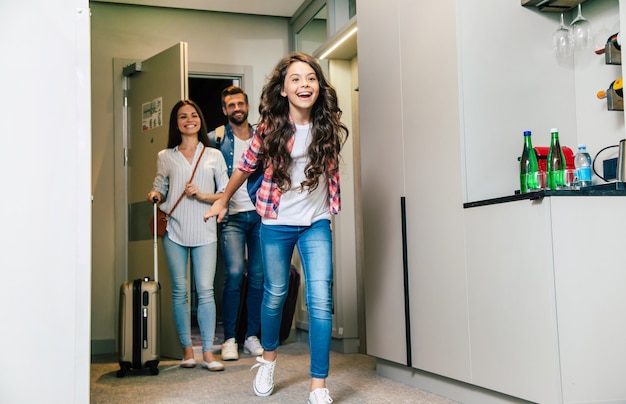 Una familia feliz entrando en la habitación del hotel.