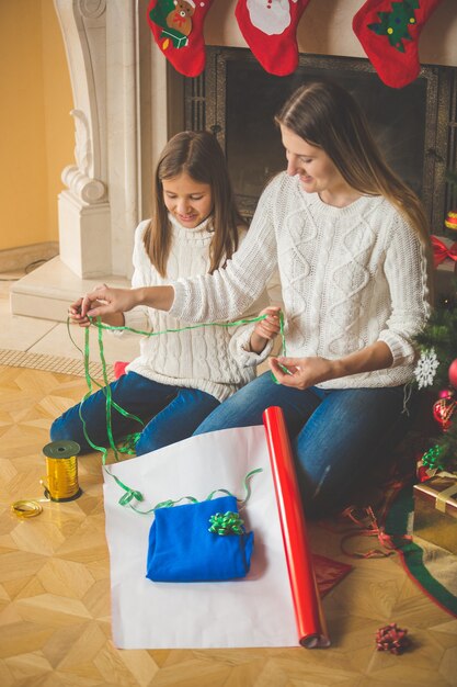 Familia feliz envolver los regalos de Navidad en la chimenea