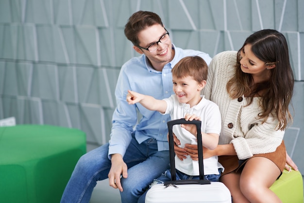 Foto familia feliz esperando en el vestíbulo del hotel