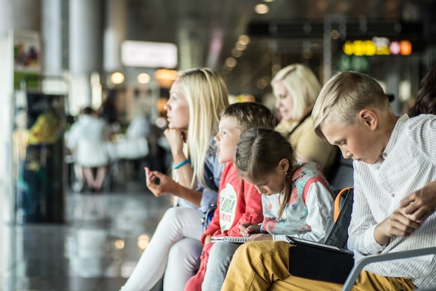 Familia feliz esperando el vuelo e ir de vacaciones