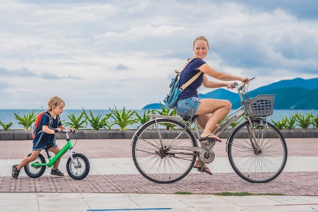 Família feliz está andando de bicicleta ao ar livre e sorrindo. a mãe de bicicleta e o filho de bicicleta.