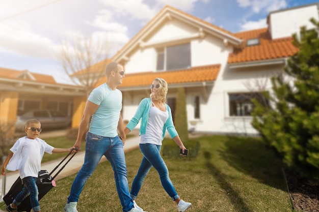 Familia feliz. familia en el fondo de una nueva casa. La nueva casa moderna está en el fondo.