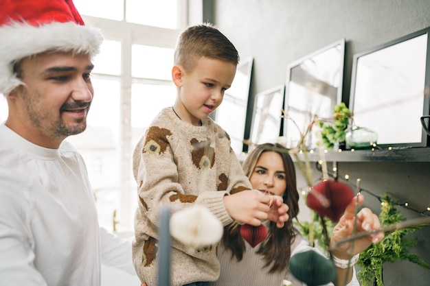 Família feliz fazendo decorações de natal em casa