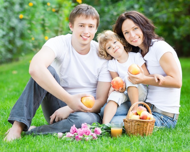 Família feliz fazendo piquenique ao ar livre no parque primavera Conceito de alimentação saudável