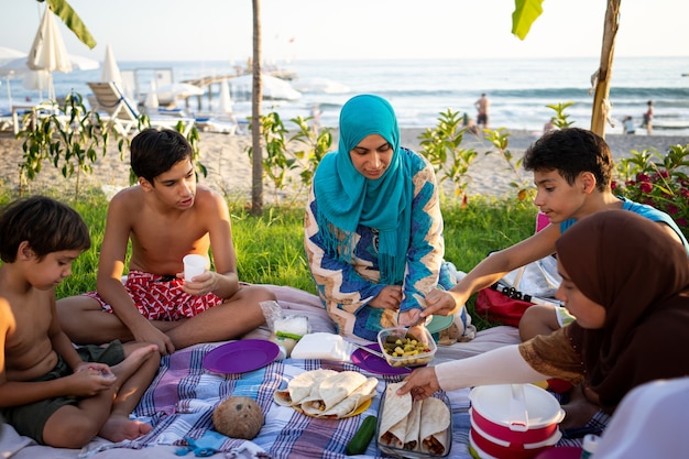 Família feliz fazendo piquenique na praia perto do mar