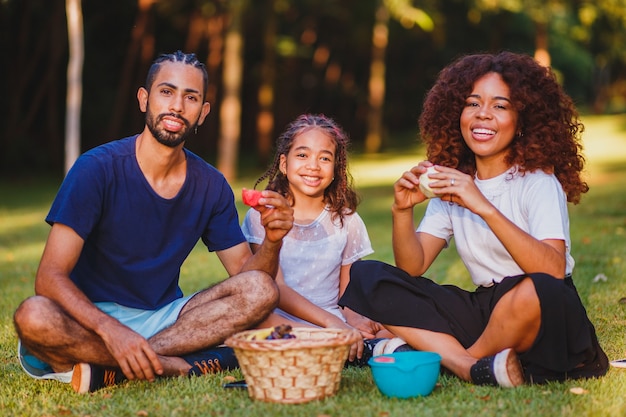 Família feliz fazendo piquenique no parque