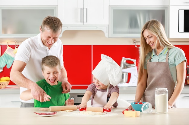 Família feliz fazendo pizza na cozinha