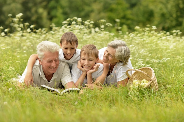 Família feliz fofa e sorridente na floresta de verão