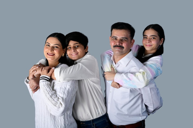 família feliz frente pose contra parede cinza modelo indiano do paquistanês