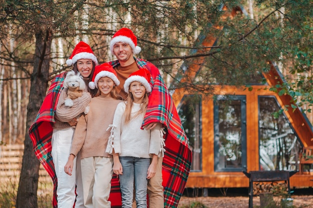 Familia feliz con gorro de Papá Noel disfrutando de las vacaciones de Navidad