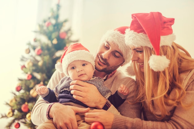 Familia feliz en la habitación con el árbol de Navidad