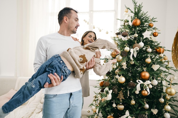 Familia feliz haciendo adornos navideños en casa juntos