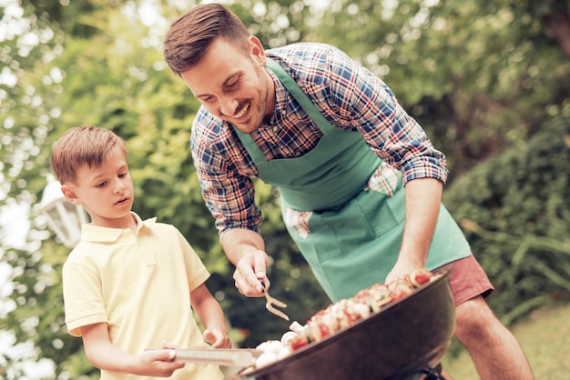 Familia feliz haciendo barbacoa en un día soleado