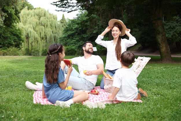 Familia feliz haciendo picnic juntos en el parque