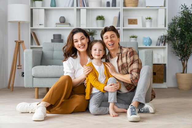 ¡Familia feliz! Hija de niño con madre y padre. Mamá, papá y niña riendo y abrazándose.