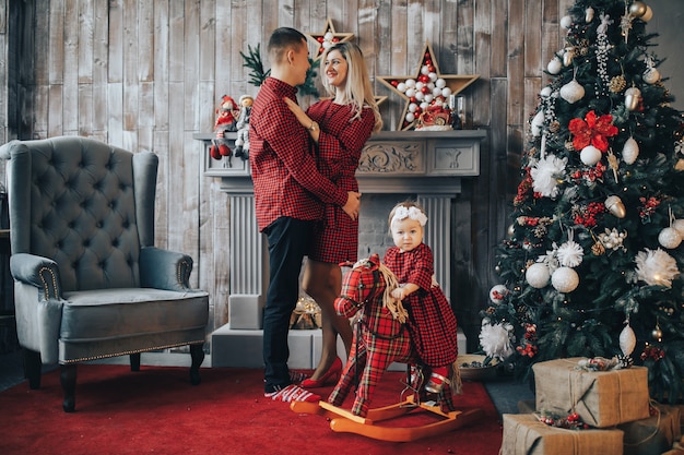 Familia feliz con una hija pequeña el día de Navidad