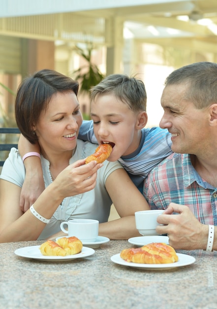 Foto familia feliz con hijo en el desayuno en la mesa