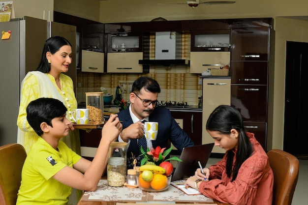 família feliz, hora do chá, sentado na mesa de jantar modelo indiano do paquistanês