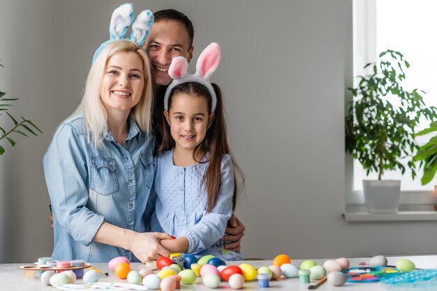 Foto familia feliz con huevos de pascua. familia feliz preparándose para pascua.