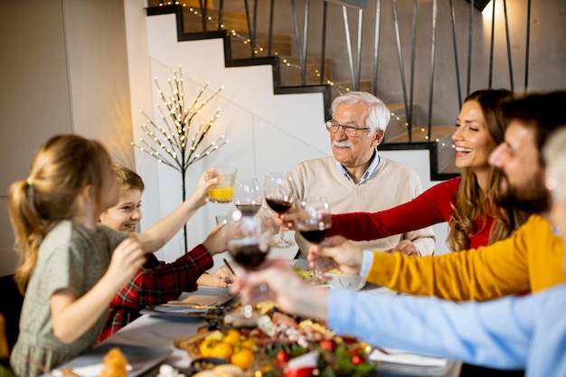 Família feliz jantando com vinho tinto em casa