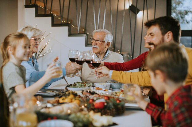 Família feliz jantando com vinho tinto em casa