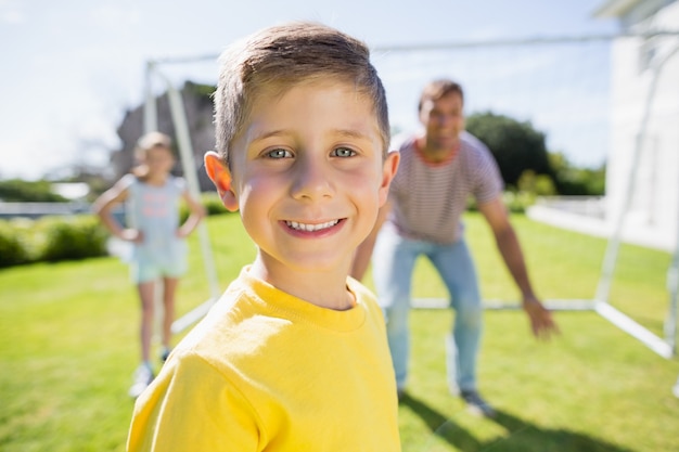 Família feliz jogando futebol no parque