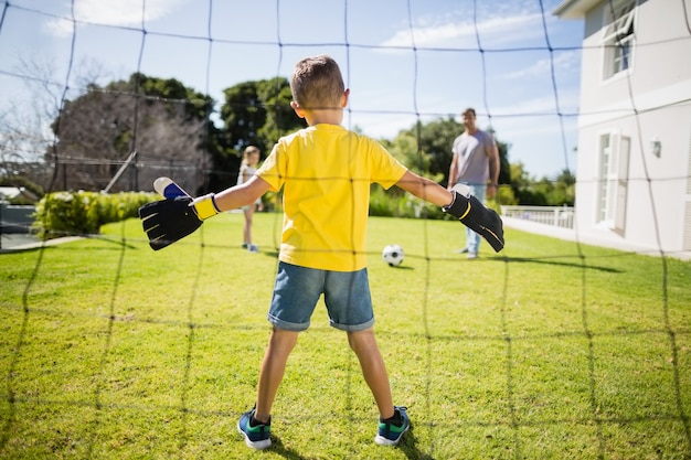 Família feliz jogando futebol no parque