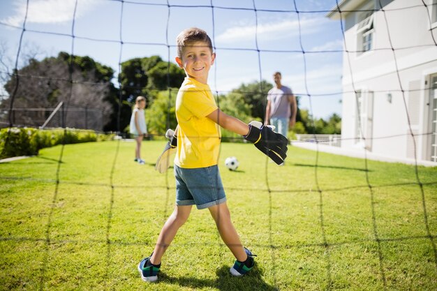 Família feliz jogando futebol no parque