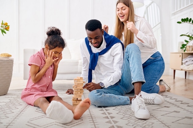 Família feliz jogando jogo na sala de estar
