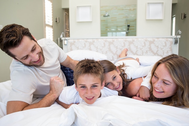 Família feliz jogando na cama