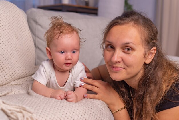 Família feliz, jovem mãe, babá lendo um livro contando às crianças um conto de fadas engraçado sentado