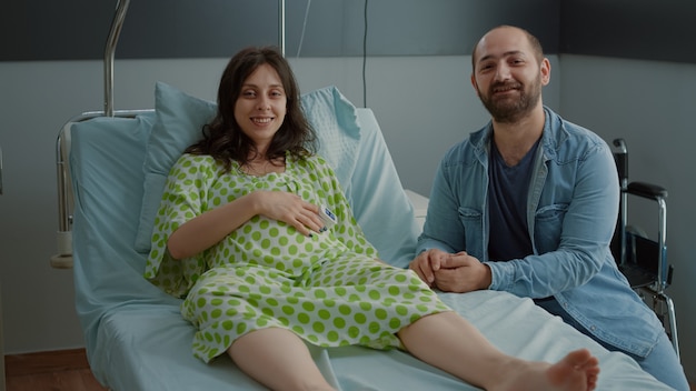 Familia feliz joven esperando el parto en la sala del hospital