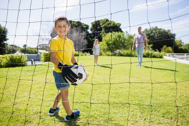 Familia feliz jugando al fútbol en el parque