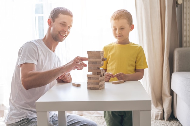 Familia feliz jugando al juego de mesa juntos. Casa. Acogedor.