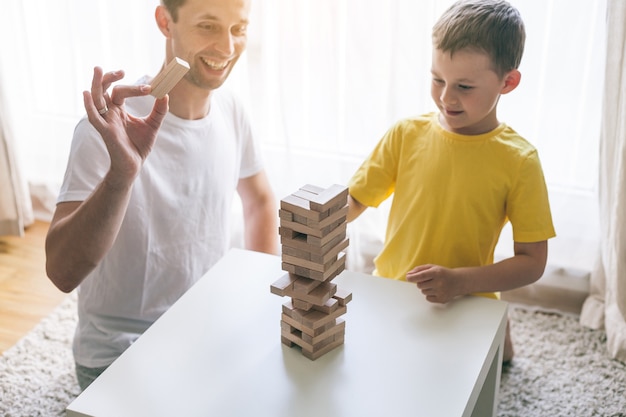 Familia feliz jugando al juego de mesa juntos. Casa. Acogedor.