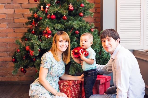 Familia feliz jugando con bolas de Navidad en casa