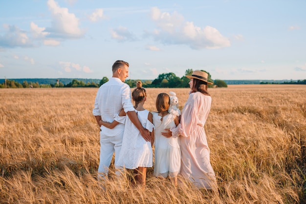 Familia feliz jugando en un campo de trigo