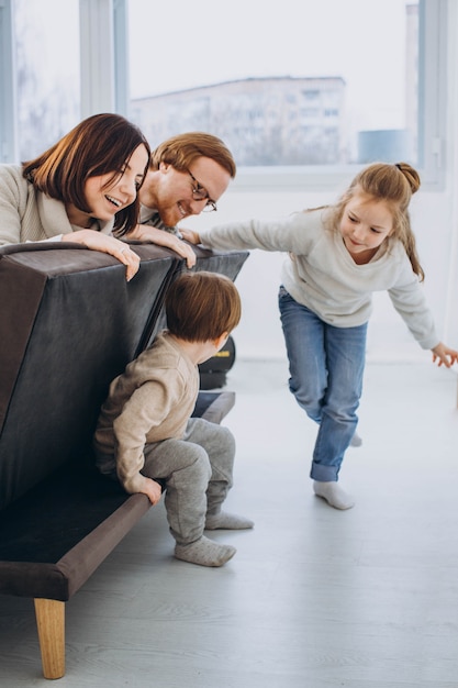 Familia feliz jugando y divirtiéndose juntos en el sofá