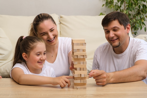 Familia feliz jugando con juegos de bloques de madera en casa